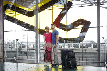 Lächelndes Paar auf dem Flughafen - RHF02214