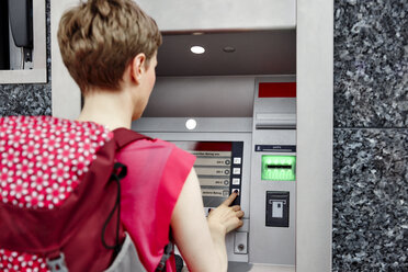 Rückansicht einer Frau an einem Geldautomaten - RHF02231