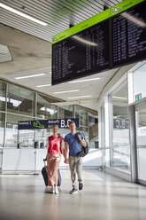 Glückliches Paar geht Hand in Hand am Flughafen - RHF02244