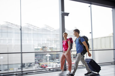 Lächelndes Paar beim Spaziergang auf dem Flughafen - RHF02254