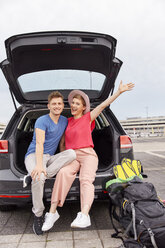 Portrait of happy young couple in a car at the airport - RHF02268