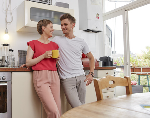 Glückliches Paar zu Hause bei einer Kaffeepause in der Küche, lizenzfreies Stockfoto