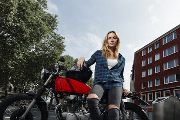 Porträt einer selbstbewussten jungen Frau mit Motorrad - RHF02319