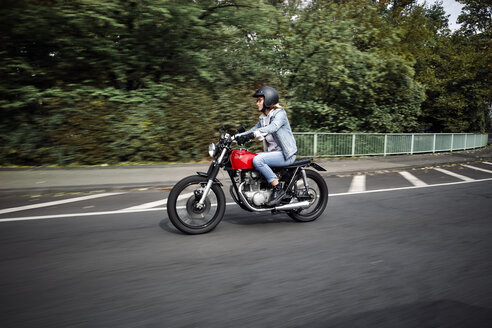 Young woman riding motorcycle on a street - RHF02322