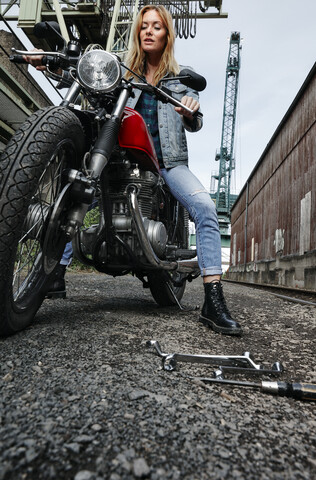 Portrait of confident young woman on motorcycle stock photo