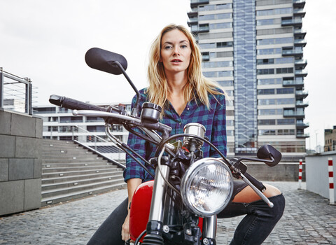 Portrait of confident young woman on motorcycle stock photo