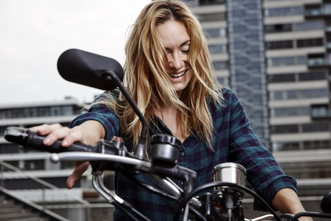 Lachende junge Frau auf Motorrad, lizenzfreies Stockfoto