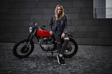 Portrait of confident young woman with motorcycle - RHF02356