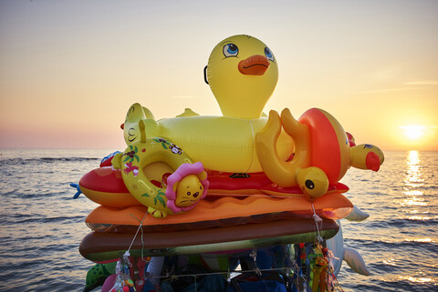 Strandspielzeug am Meer bei Sonnenuntergang, lizenzfreies Stockfoto