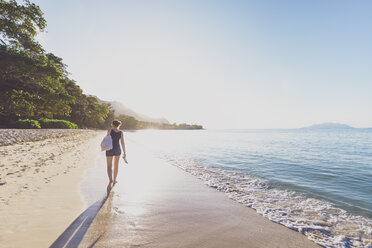 Seychellen, Mahe, Beau Vallon Beach, Frau geht bei Sonnenuntergang am Strand spazieren - MMAF00683