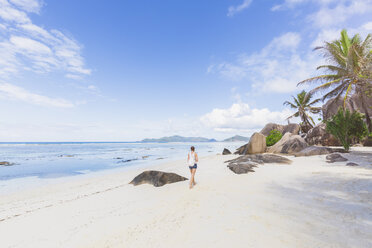 Seychelles, La Digue, Anse Source d'Argent, woman walking at the beach - MMAF00688