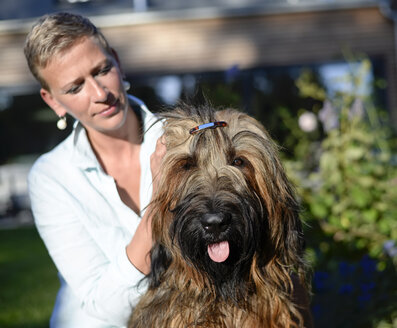 Porträt eines Hundes mit Haarspange und Besitzer im Hintergrund - BFRF01938