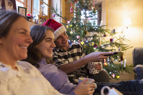 Die Familie entspannt sich und sieht im Weihnachtswohnzimmer fern - HOXF03951