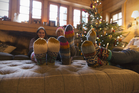 Familie mit bunten Socken entspannt sich im Weihnachtswohnzimmer, lizenzfreies Stockfoto