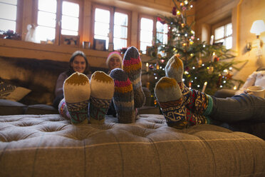 Familie mit bunten Socken entspannt sich im Weihnachtswohnzimmer - HOXF03967