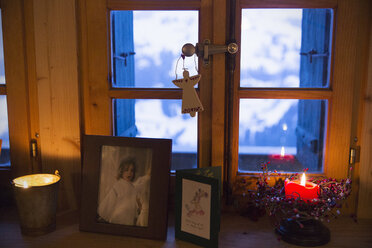 Weihnachtsschmuck und Kerze auf der Fensterbank - HOXF03969