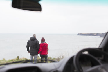 Ehepaar mit Blick auf das Meer außerhalb des Autos - HOXF03971