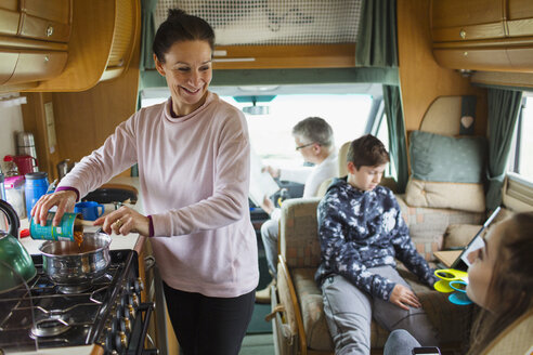 Glückliche Familie beim Kochen und Entspannen im Wohnmobil - HOXF03985