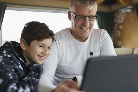 Vater und Sohn benutzen digitales Tablet im Wohnmobil, lizenzfreies Stockfoto