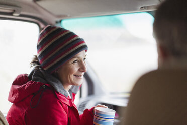Smiling woman drinking coffee in motor home - HOXF03996