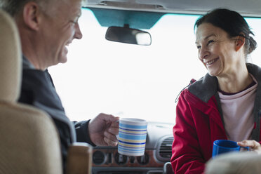 Glückliches Paar trinkt Kaffee im Wohnmobil - HOXF04006