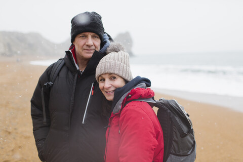 Porträtpaar in warmer Kleidung am Winterstrand, lizenzfreies Stockfoto