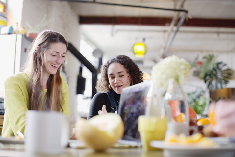 Junge Frauen Mitbewohnerinnen Freunde am Küchentisch, lizenzfreies Stockfoto