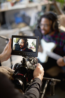 Videofilmer filmt jungen männlichen Musiker beim Singen und Gitarrenspielen - HOXF04070