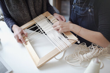 Women friends assembling string frame art - HOXF04091