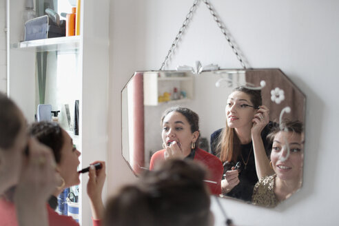 Junge Freundinnen machen sich bereit und tragen Make-up im Badezimmerspiegel auf - HOXF04093