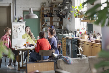 Young college student roommate friends studying at kitchen table in apartment - HOXF04099