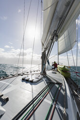 Frau am Bug eines Segelboots auf sonnigem Meer, Vava'u, Tonga, Pazifischer Ozean, - HOXF04155