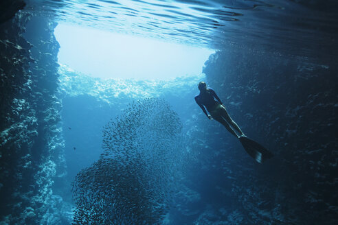 Junge Frau beim Schnorcheln unter Wasser zwischen Fischschwärmen, Vava'u, Tonga, Pazifischer Ozean - HOXF04157