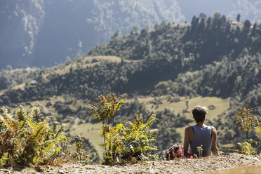 Female hiker resting, enjoying sunny scenic view, Supi Bageshwar, Uttarakhand, Indian Himalayan Foothills - HOXF04171