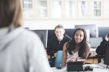 Lächelnde multiethnische Schüler, die im Computerraum der High School lernen - MASF09455