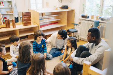 Hochformatige Ansicht von Lehrern und Schülern, die im Klassenzimmer der Kinderbetreuung sitzen - MASF09513