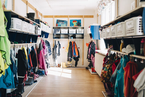 Verschiedene Kleider hängen in der Garderobe der Vorschule - MASF09518