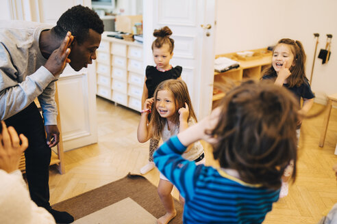 Hohe Winkel Ansicht der Lehrer und Schüler tanzen im Klassenzimmer in der Kinderbetreuung - MASF09587