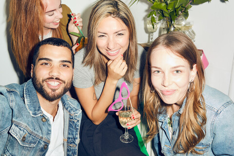 Porträt von lächelnden jungen multiethnischen Freunden, die eine Party in einer Wohnung genießen, lizenzfreies Stockfoto