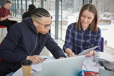 Freunde studieren mit Laptop und digitalem Tablet am Tisch in der Universitätscafeteria - MASF09683