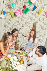 Kippaufnahme junger multiethnischer Freunde, die in einer Wohnung sitzend eine Dinnerparty genießen - MASF09689