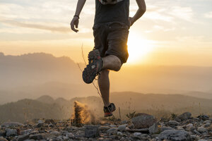 Spanien, Barcelona, Naturpark von Sant Llorenc, Mann läuft in den Bergen bei Sonnenuntergang - AFVF01894