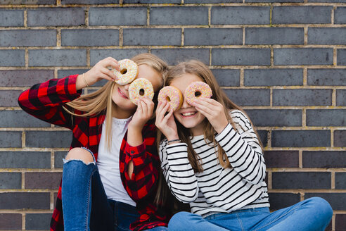 Two girls having fun with doughnuts - NMSF00282