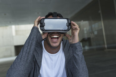 Aufgeregter junger Mann mit Virtual-Reality-Brille - JPTF00051