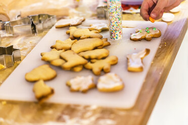 Girl's hand decorating Christmas cookies - JFEF00902