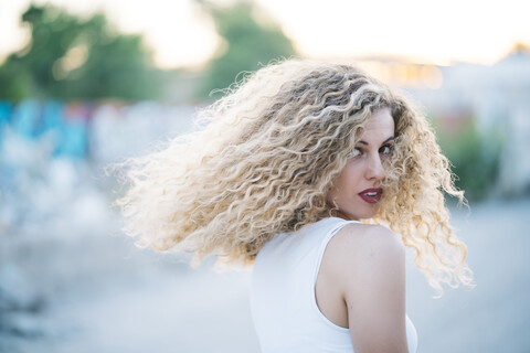 Blonde junge Frau mit lockigem Haar, lizenzfreies Stockfoto