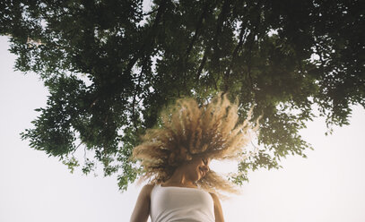 Young woman with blond ringlets tossing her hair - OCMF00019