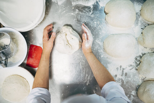 Bäcker bei der Arbeit mit Teig in einer Bäckerei - OCMF00040