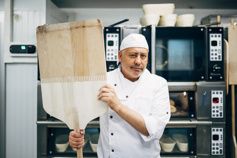 Porträt eines Bäckers mit Schale in einer Bäckerei, lizenzfreies Stockfoto