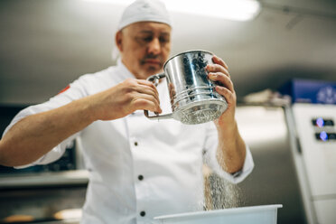 Bäcker bei der Arbeit mit Mehlsieb in einer Bäckerei - OCMF00045